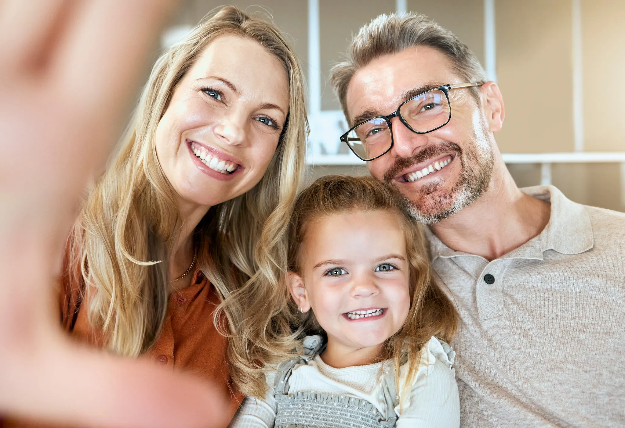 Parents and child taking a selfie with beautiful smiles, great for oral care promotions
