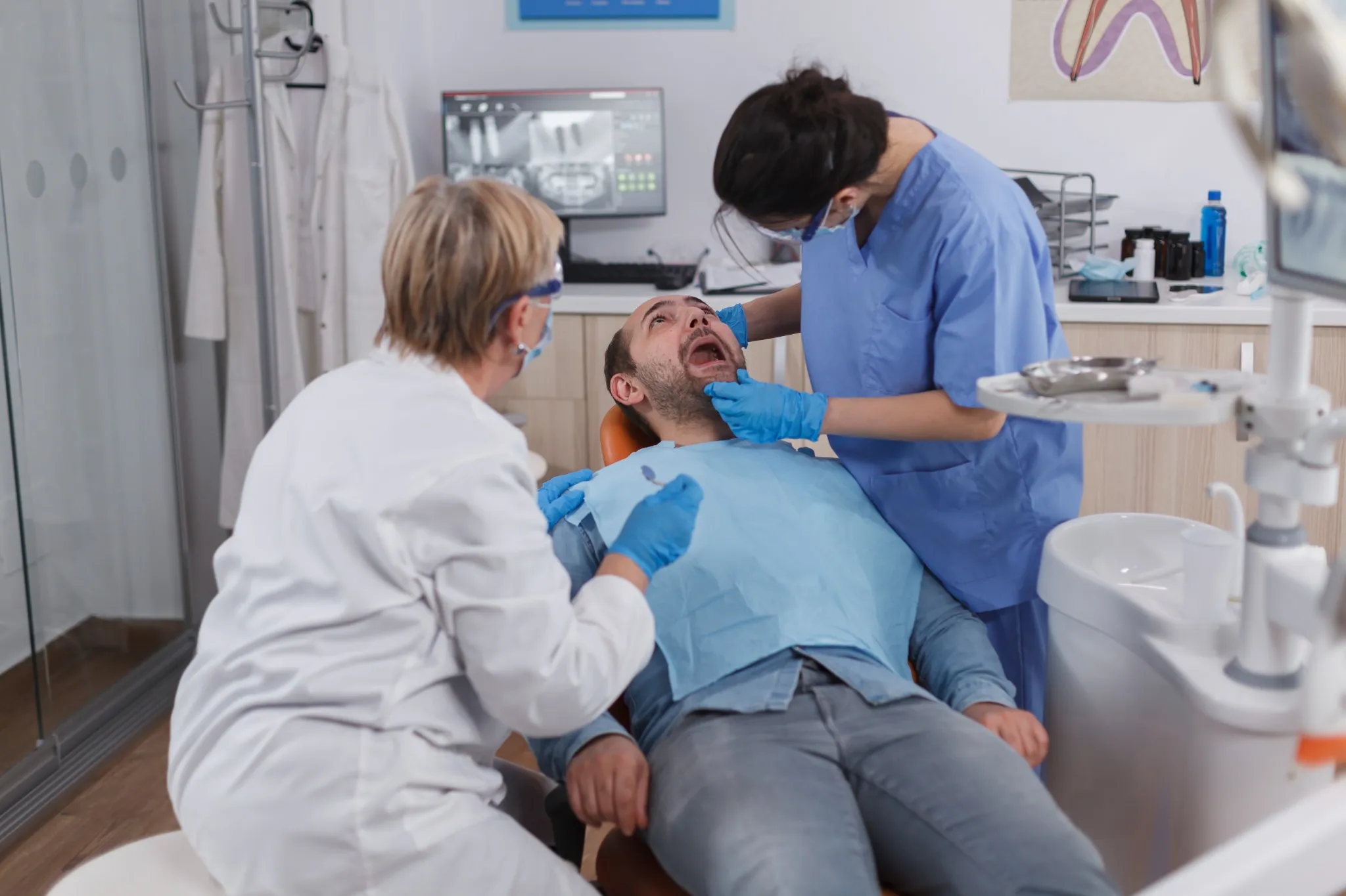 Dentist examining a patient's jaw for TMJ symptoms in a Fresno dental clinic