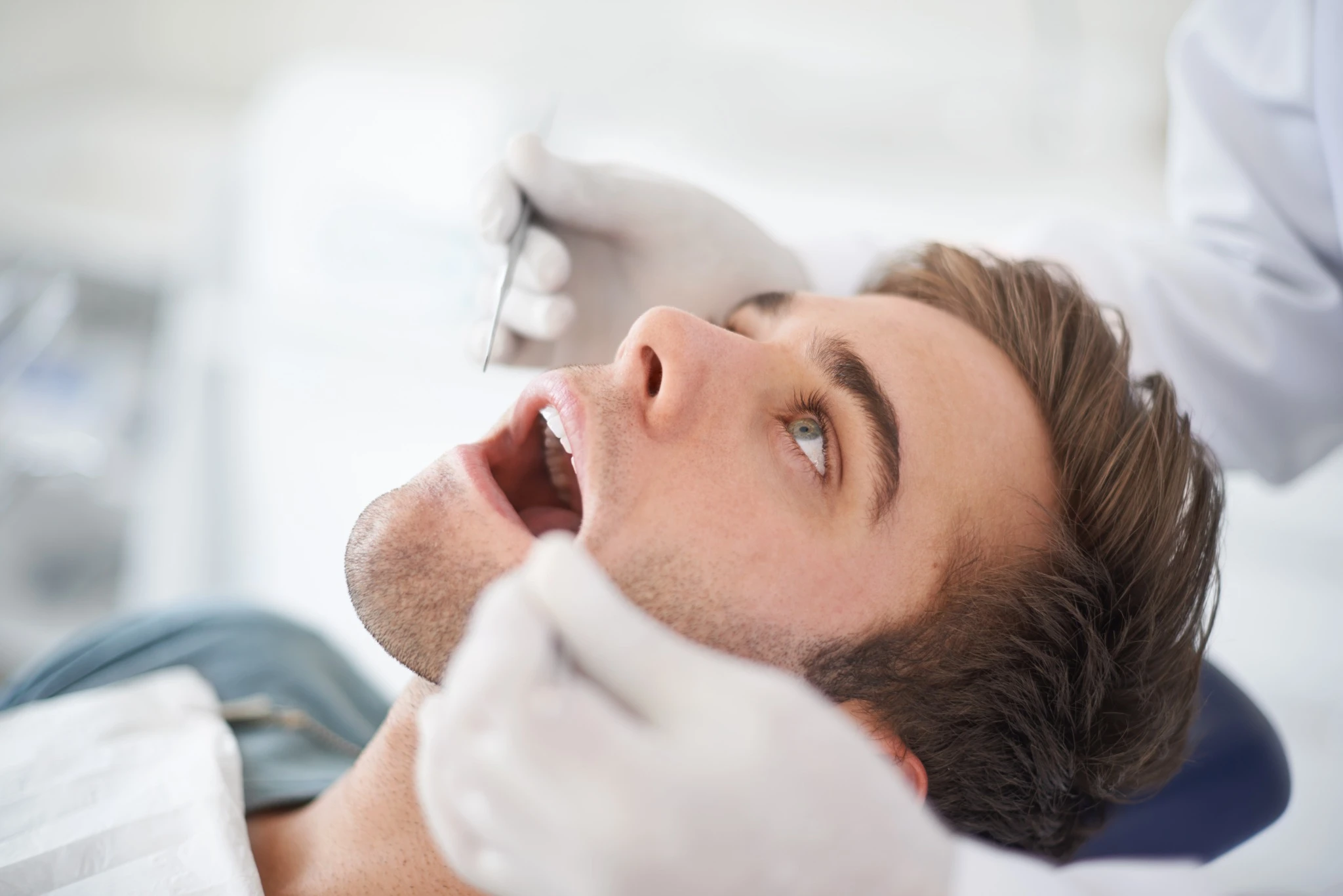 Dentist inspecting tooth for possible extraction
