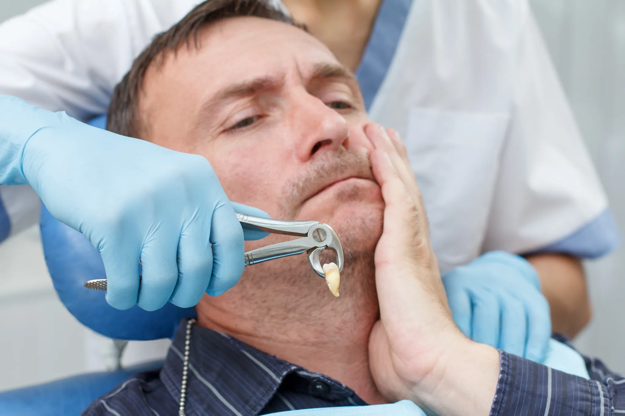 Dentist performing a tooth extraction on a patient in Fresno dental clinic